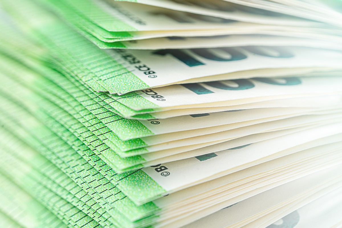 Geldwaesche Nahaufnahme gestapelter 100-Euro-Scheine, die den finanziellen Aspekt von Geldwäsche und Wirtschaftskriminalität symbolisieren.